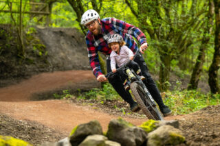 man and child riding ebike off road