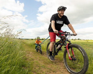 Father and son ride mountain bike with Kids Ride Shotgun TowRope