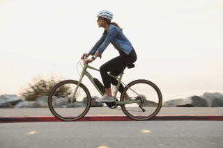 woman riding ebike on road in denim jacket